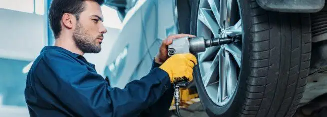 mechanic installing new tires on a car