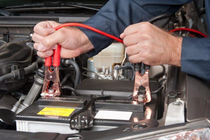 The Mufflerman, Mechanic Near Me A mechanic expertly uses red jumper cables to connect a car battery under the hood. Skilled hands grip the cable clamps, ready to jump-start your vehicle. If youre in need, search for Car Battery Service Near Me to find help close by.