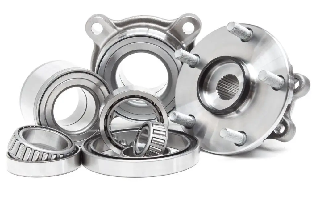The Mufflerman A collection of shiny metal bearings and wheel hub assemblies, ideal for both Wheel Bearing Replacement and Services, neatly arranged on a white background. The components showcase intricate grooves and smooth surfaces, highlighting their precision craftsmanship.