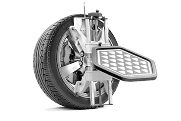 The Mufflerman A car wheel with an attached alignment tool, showcasing a grid pattern, is essential for precise vehicle service. Mounted on a machinery setup, its used for wheel alignment calibration. The tire features detailed tread and is connected to a robust metallic apparatus.