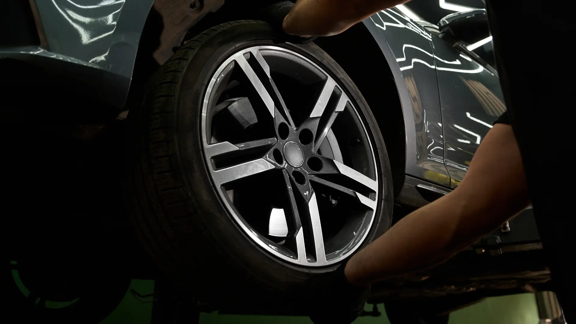 Technician checking a tire and hub while diagnosing wheel bearing noise