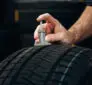 Technician checking tread depth to decide whether to replace two winter tires or all four